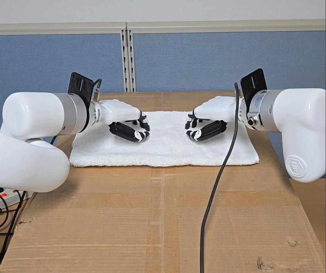 Dual-arm robot handling a soft material on a towel with robot hands
